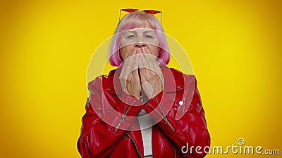 Frightened elderly woman closing her mouth with hand, gestures no, refusing to tell terrible secret Stock Photo