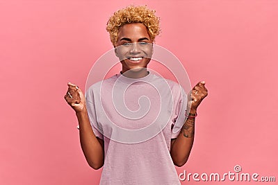 I won. Winning success happy black woman with blond hair celebrating being a winner, clenches fists in victory gesture Stock Photo