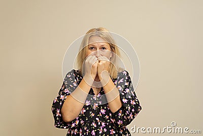 I& x27;m so scared. Anxious caucasian blonde woman biting her nails while she feeling worried and stressed, isolated over Stock Photo