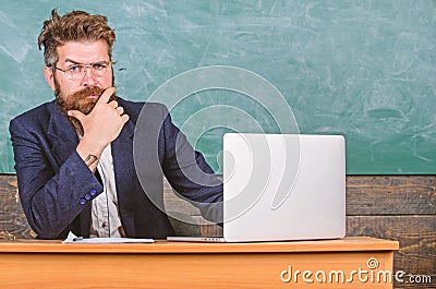 I am your new teacher. Teacher bearded hipster with eyeglasses sit in classroom chalkboard background. School teacher Stock Photo