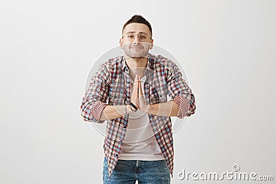 I am at your service, sensei. Indoor shot of positive emotive young guy in glasses bowing while greeting someone in Stock Photo