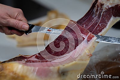 Iberian ham cut into small slices with a knife. Stock Photo