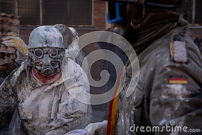 A man dressed as a soldier with a mask in the middle of a battle with flour and eggs at a traditional winter festival Editorial Stock Photo