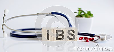 IBS the word is written on wooden cubes and sthetoscope and piils . Medicine Stock Photo