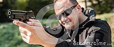 Police agent and bodyguard pointing pistol to protect from attacker Stock Photo