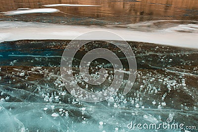 Ice bubbles rising up through blue ice Stock Photo