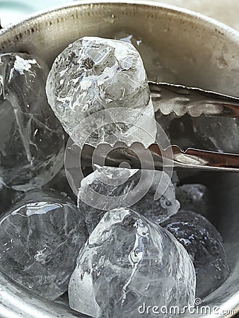 Ice bucket with hand holding tongs Stock Photo