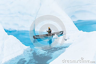 Ice climbing guide on the Matanuska Glacier paddling a canoe through narrow flooded canyons of a glacier lake Stock Photo