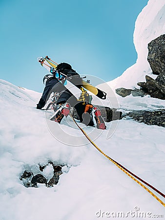 Ice climbing: mountaineer on a mixed route of snow and rock during the winter Stock Photo