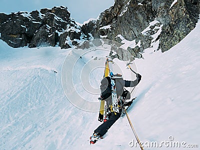 Ice climbing: mountaineer on a mixed route of snow and rock during the winter Stock Photo