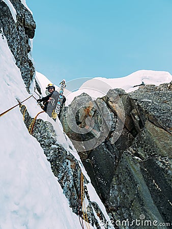 Ice climbing: mountaineer on a mixed route of snow and rock during the winter Stock Photo