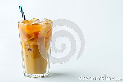 Ice coffee in a tall glass with cream poured over and coffee beans. Cold summer drink on a light background. With copy Stock Photo