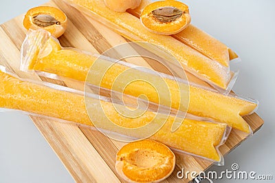 Ice cream in a bag with apricot sweet frozen homemade. Brazilian Ding-ding, chup-chup Stock Photo