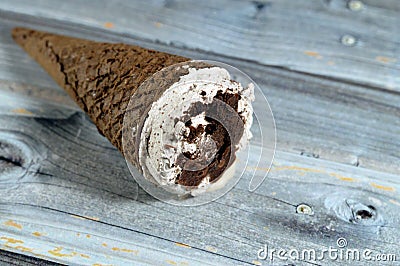 Ice cream of cocoa chocolate and vanilla cone with topping of chocolate chips cookies pieces in crispy wafer cones, melting cold Stock Photo