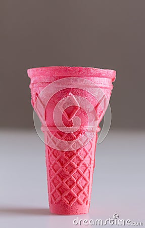 Ice cream cone against grey background - Pink wafer ice Stock Photo