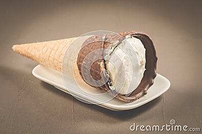 ice cream with cone in chocolate on a white plate/ice cream with cone in chocolate on a white plate on a dark background Stock Photo