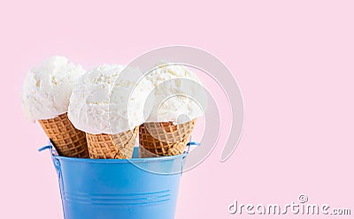 Ice cream cones in a blue bucket on a pink background. A wafer-style ice cream cone. Stock Photo