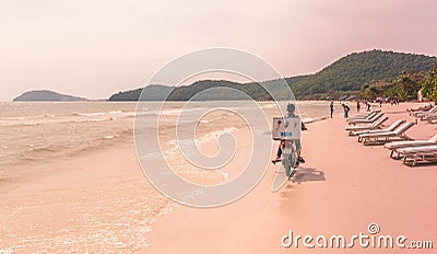 Phu Quoc Island, Vietnam: Unidentified Ice cream sailor driving motorcycle at sandy beach Editorial Stock Photo