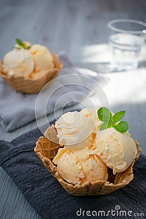 Ice cream scoops with vanilla ice cream in a bowl with mint. Vertical photo Stock Photo