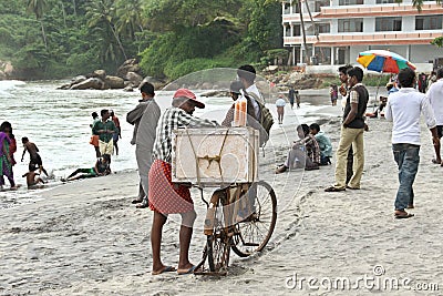 Ice cream seller on a busy beach with bicycle Editorial Stock Photo