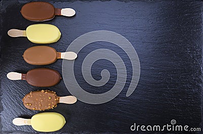 Ice cream on stick covered with chocolate on black Stock Photo