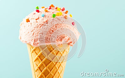 Ice cream. Strawberry or raspberry flavor icecream in waffle cone over blue background Stock Photo