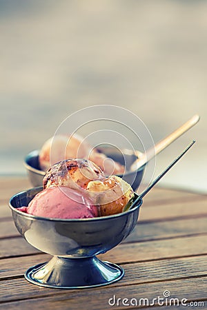 Ice cream in two retro metal bowls on a wooden table. Backgrounds created for your text. Stock Photo