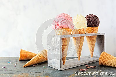 Ice cream cone table scene against marble, strawberry, vanilla and chocolate flavors Stock Photo