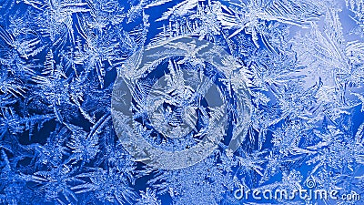 Ice crystals close-up on a window glass in winter. Dark blue and white background or wallpaper. Mystical fabulous abstract pattern Stock Photo