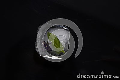 Ice cube against a dark background. Stock Photo