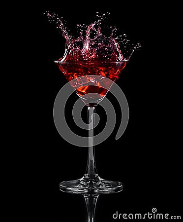 Ice cube dropped into a glass of grape juice Stock Photo