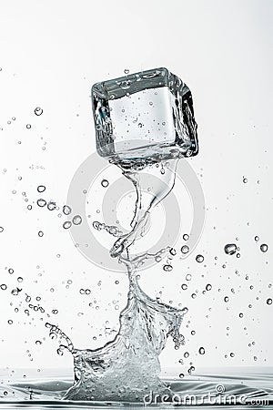 Ice cube splashing into water on a white background, capturing the dynamic motion and refreshing clarity Stock Photo