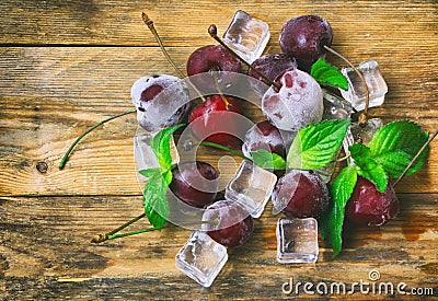 Ice cubes, frozen ripe cherry, mint leaves Stock Photo