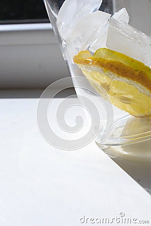 Ice cubes and pieces of lemon in a glass Stock Photo
