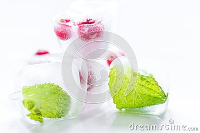 Ice cubes with red berries and mint white background Stock Photo