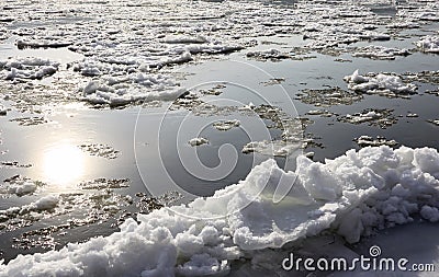 Ice drift on the river. Reflection of the sun in autumn water Stock Photo