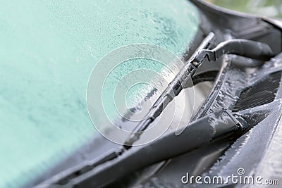 Ice flowers, frozen car window.The ice-cold frost forms ice crystals in beautiful unique patterns on the window, Hood and wiper o Stock Photo