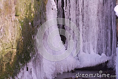 Ice on the granite wall melting under spring sun Stock Photo