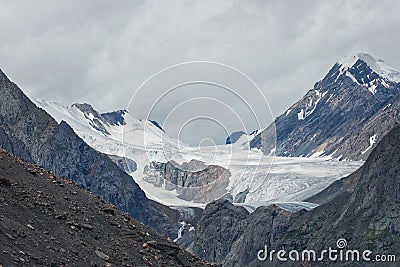 Ice high in the mountains. Aktru glaciers in the Altai mountains clear ice among rocks and mountain peaks Stock Photo