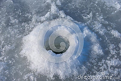 Ice hole drilled with a fishing auger Stock Photo