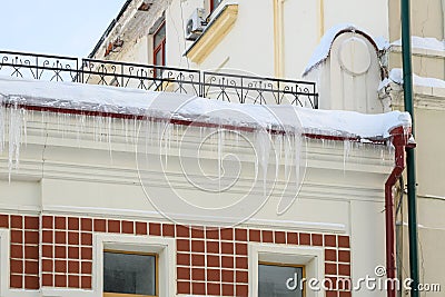 Ice icicles dangerously hanging from the roof Stock Photo