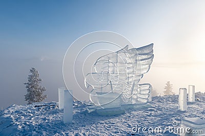 Ice sculpture of eagle. Winter landscape with a view of the Yakutsk city from the hill. The city is hidden under dense fog Stock Photo
