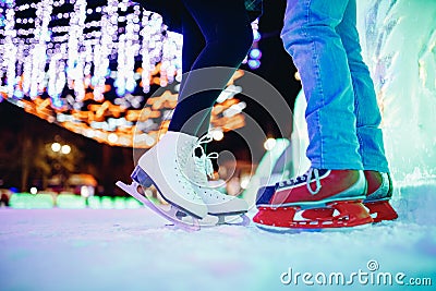 Ice skating lover couple having fun on snow winter holidays night illumination Stock Photo