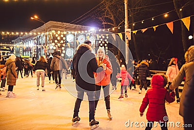 Ice skating together. Romantic winter vacation in ice arena. Young couple skating at ice rink. Best Christmas ever. Winter fun. Editorial Stock Photo