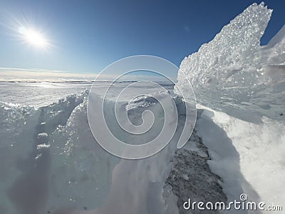 Ice slopes in sunny winter day, transparent ice of blue color, purely blue sky, long shadows, a pure snow-covered virgin Stock Photo