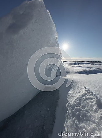 Ice slopes in sunny winter day, transparent ice of blue color, purely blue sky, long shadows, a pure snow-covered virgin Stock Photo