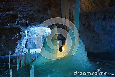 Ice stalagmites and stalactites illuminated by candles and fluorescent light inside the marble mine Stock Photo