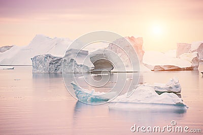 Icebergs on the shore of Atlantic ocean at sunset, Greenland Stock Photo