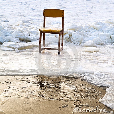 Icebound chair on edge of ice-hole in frozen lake Stock Photo