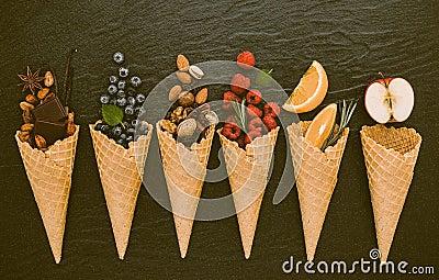 Icecreams with fruit and nut ingredients - ice cream cones on a black background Stock Photo